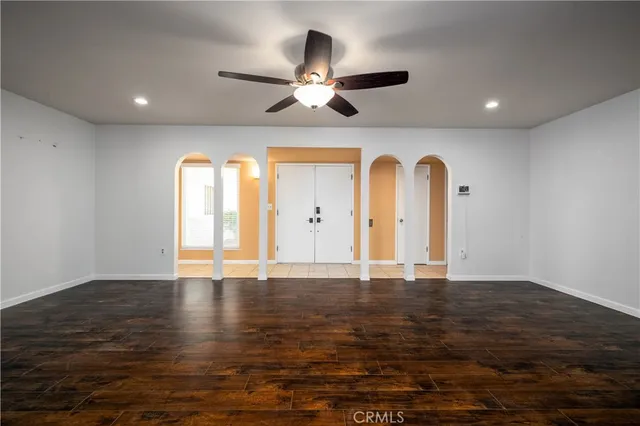 a view of an empty room with window and wooden floor