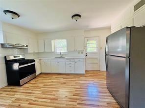 1015 West Sycamore Street Sherman, TX 75092 - Photo 20 of 35 a kitchen with granite countertop a refrigerator and a stove top oven