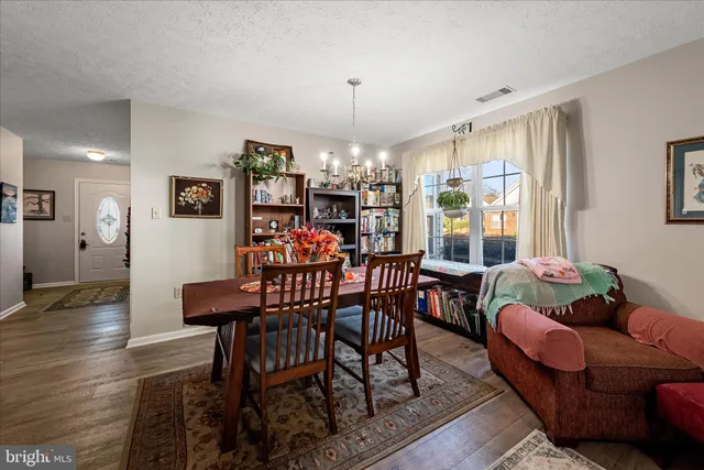 a dining room with furniture a chandelier and wooden floor