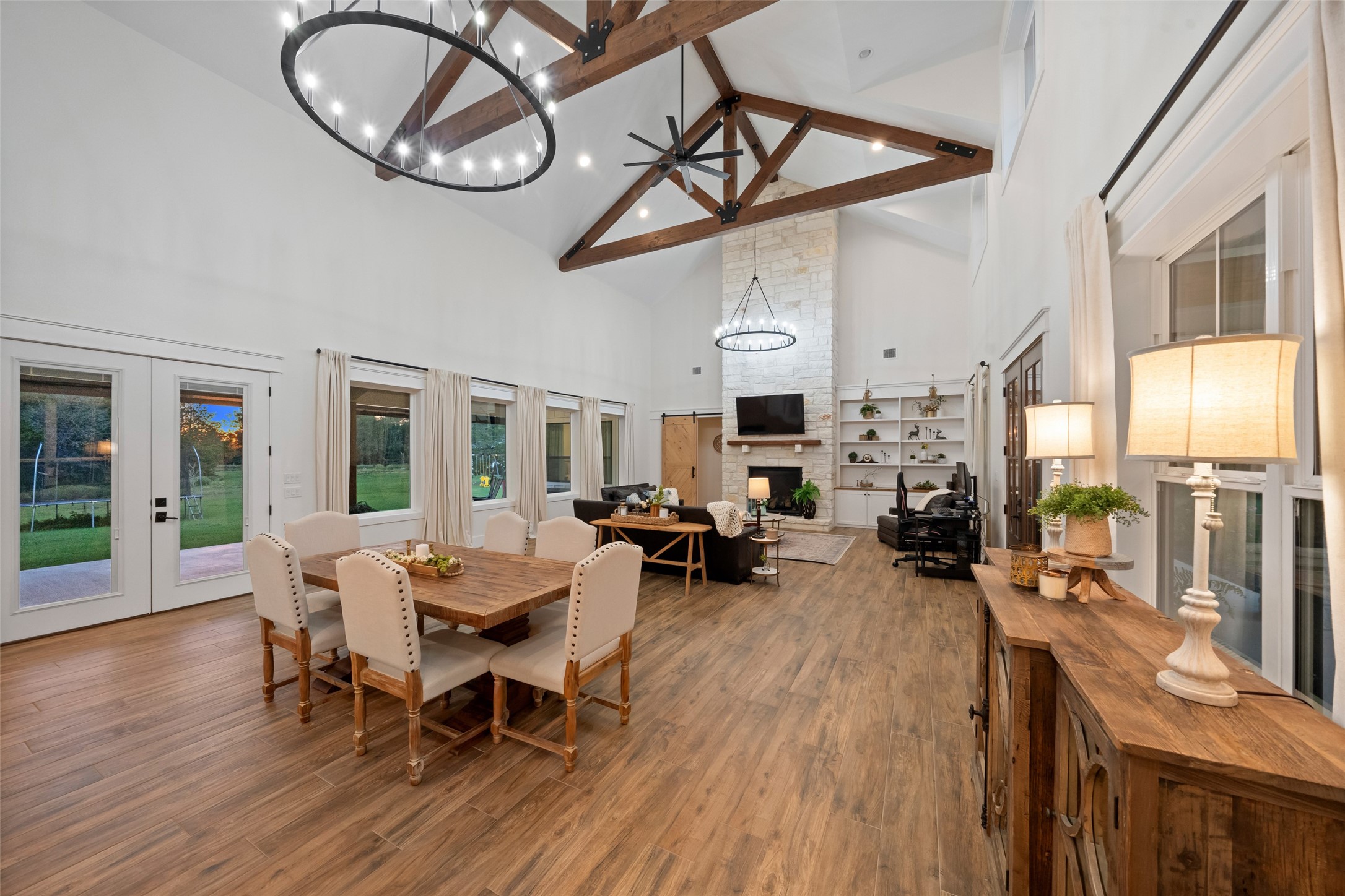 27201 Double Culvert Road Hempstead, TX 77445 - Photo 15 of 49 Wide view of the open-concept dining and living areas, highlighting dramatic vaulted ceilings with exposed trusses.