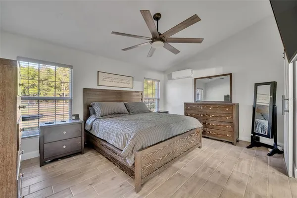 a bedroom with a bed and a mirror on the dresser