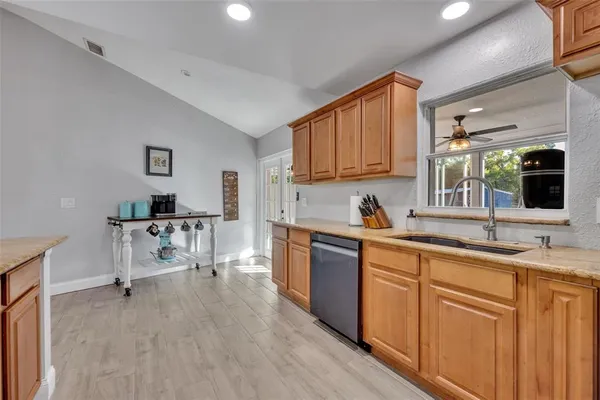 a kitchen with cabinets a sink and chairs in it