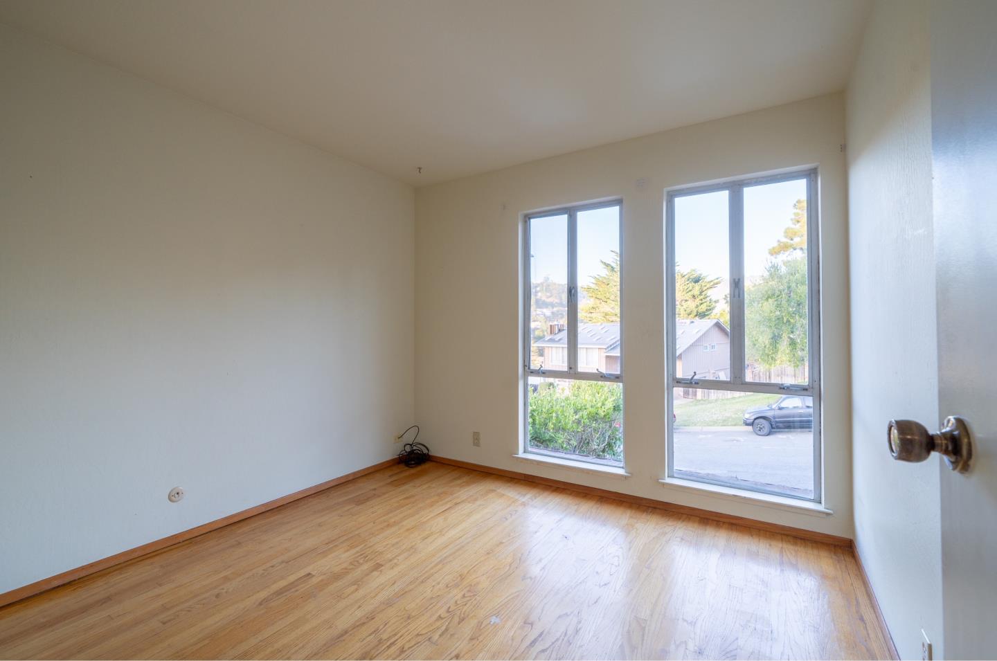 935 Park Pacifica Avenue Pacifica, CA 94044 - Photo 27 of 44 an empty room with wooden floor and windows