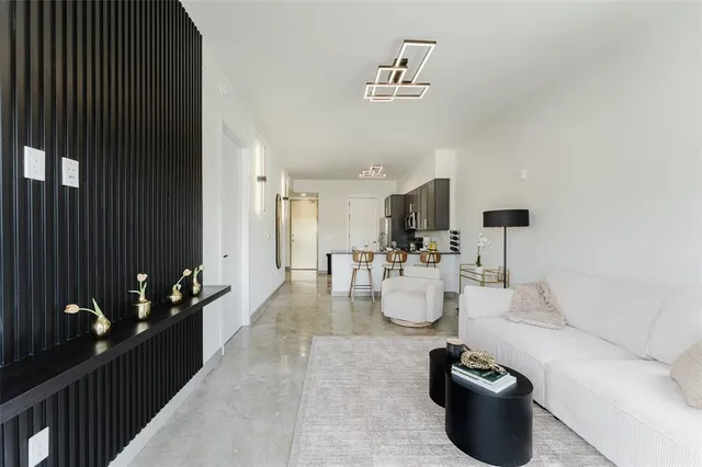 a living room with furniture and a view of kitchen