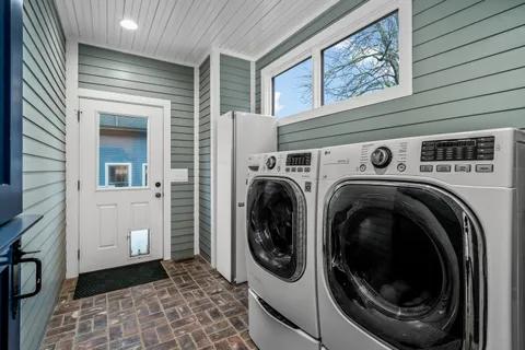 a view of a refrigerator with white cabinets and wooden floor