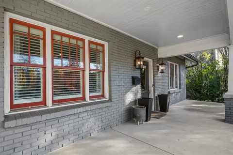 a couple of potted plants and a window in front of house
