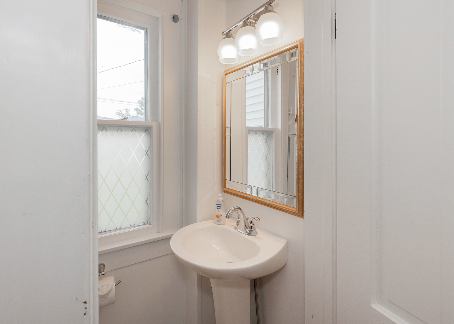 1839 15th Street Moline, IL 61265 - Photo 14 of 32 a bathroom with a sink a mirror and a window