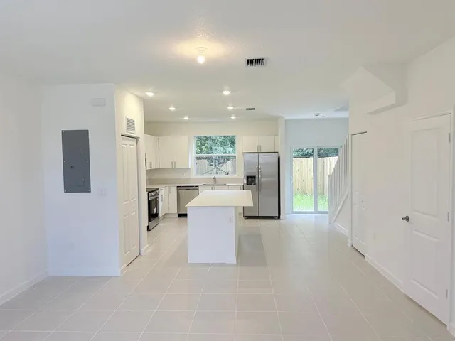 a view of a kitchen with furniture and refrigerator