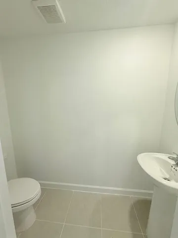 a white toilet sitting next to a white sink and vanity