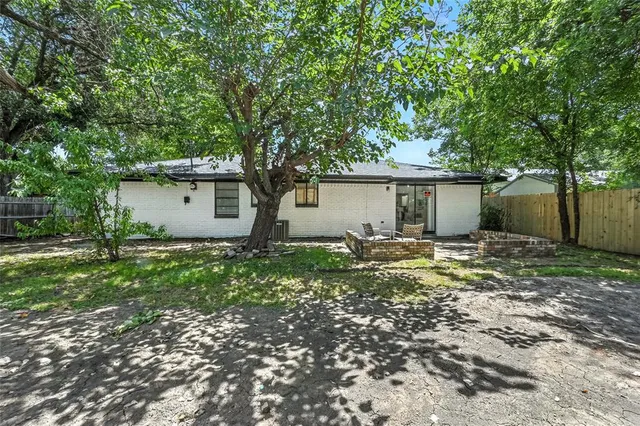 a view of a house with a backyard and tree