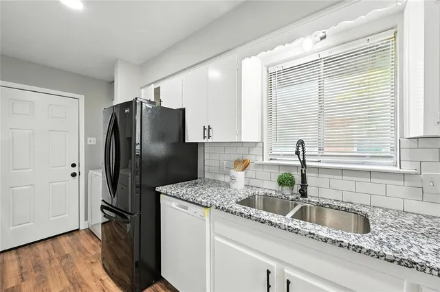 a kitchen with stainless steel appliances granite countertop a refrigerator and a sink