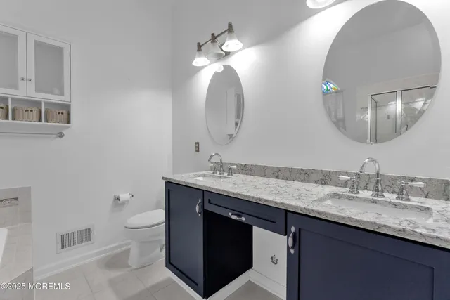 a bathroom with a granite countertop toilet sink and mirror