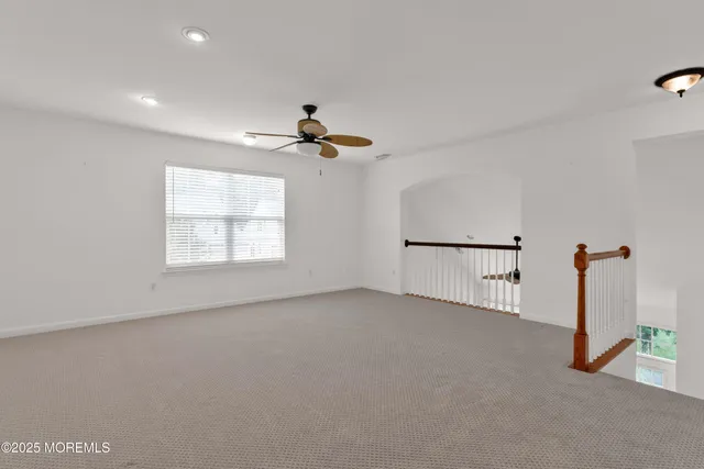 a view of a room with a ceiling fan and window