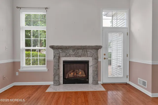 a living room with a fireplace and wooden floor