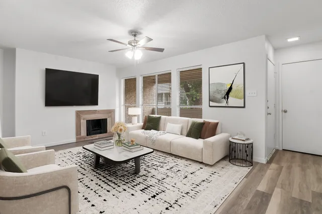 a living room with furniture a fireplace and a flat screen tv