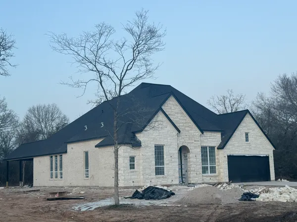 a view of a white house with a large tree