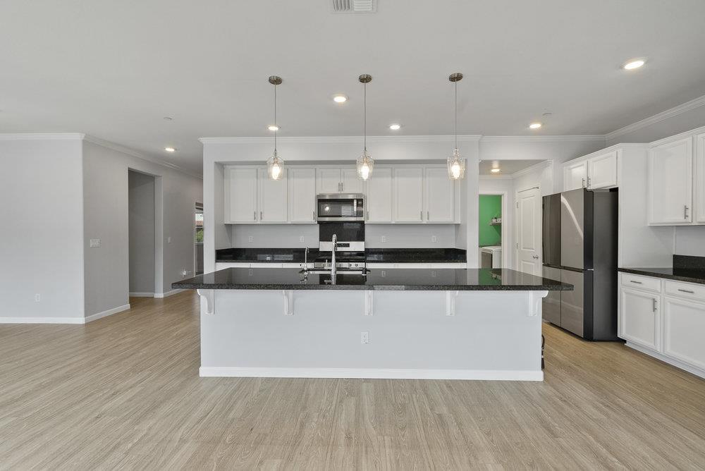 638 Summerfield Drive Soledad, CA 93960 - Photo 16 of 50 a large kitchen with stainless steel appliances a large counter top a refrigerator and a stove top oven