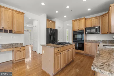 a kitchen with stainless steel appliances granite countertop a refrigerator sink and cabinets