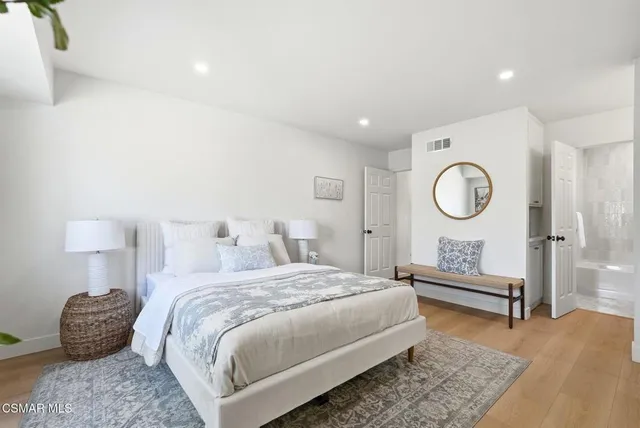 a bedroom with a bed a mirror and a lamp