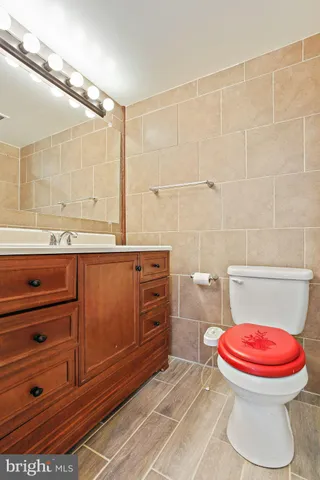 a bathroom with a toilet sink vanity and mirror