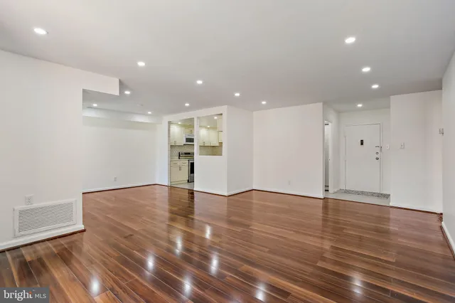 a view of an empty room with wooden floor