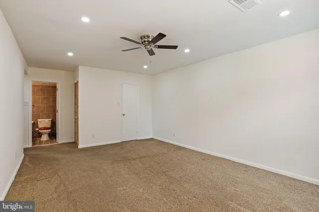 an empty room with closet and windows