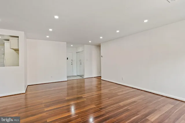 a view of an empty room with wooden floor