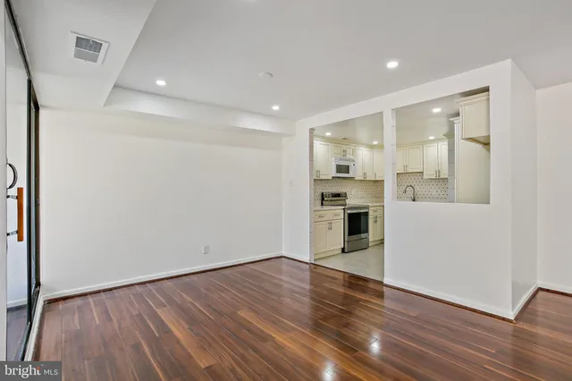 an empty room with wooden floor and fireplace