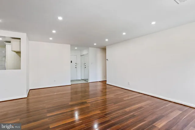 a view of an empty room with wooden floor