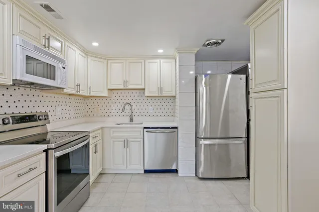 a kitchen with a refrigerator sink and cabinets