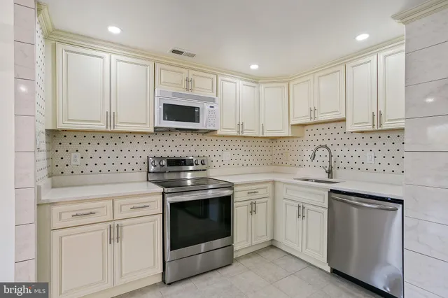 a kitchen with white cabinets appliances and sink