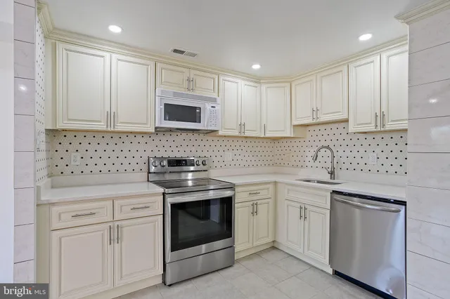 a kitchen with white cabinets appliances and sink