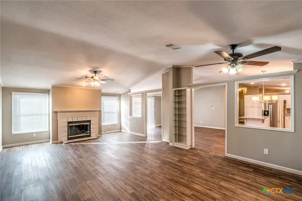a view of a livingroom with a fireplace wooden floor and chandelier