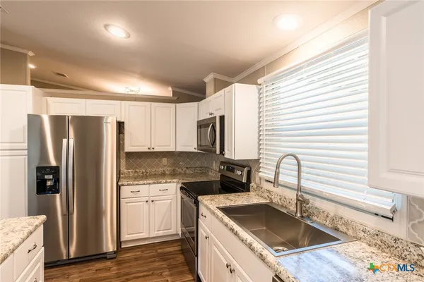 a kitchen that has a sink cabinets counter space and stainless steel appliances