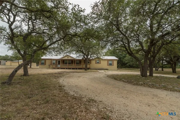 a front view of a house with a yard and trees