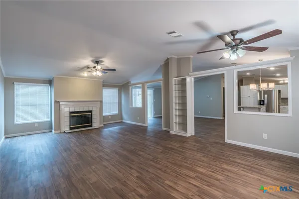 a view of a livingroom with a fireplace wooden floor and chandelier