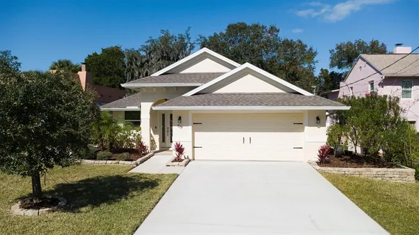 a front view of a house with a yard and trees