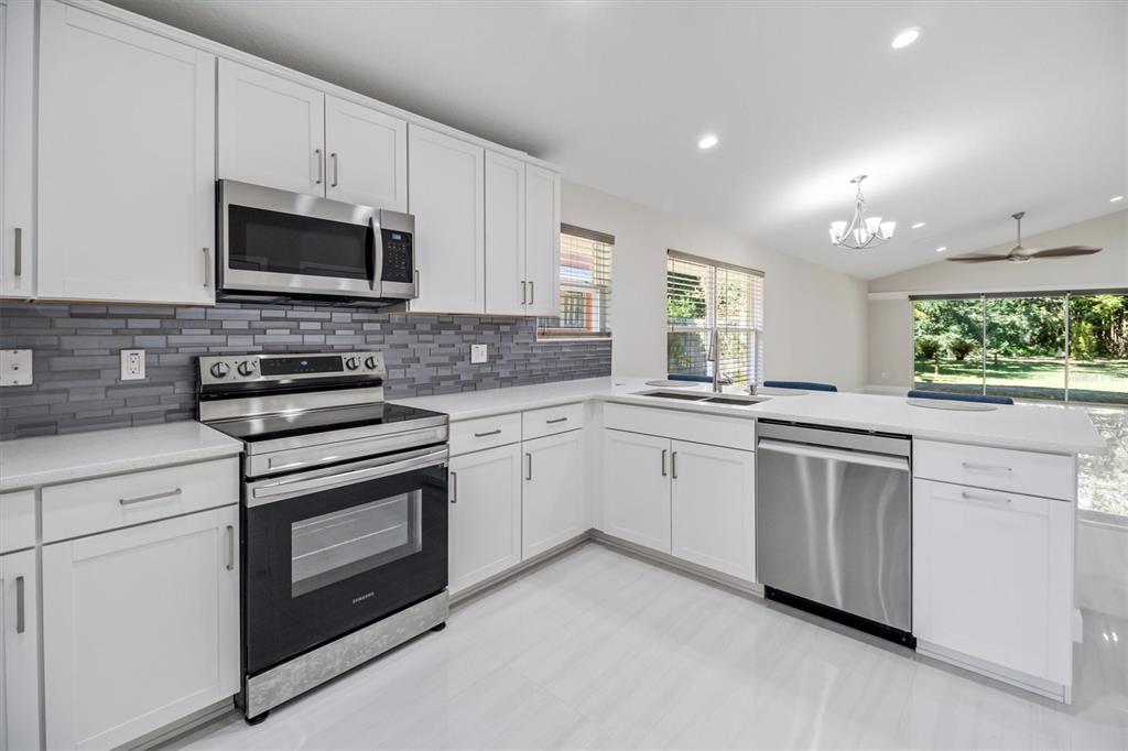 53 Wilmette Avenue Ormond Beach, FL 32174 - Photo 13 of 36 a kitchen with granite countertop white cabinets white stainless steel appliances and a sink