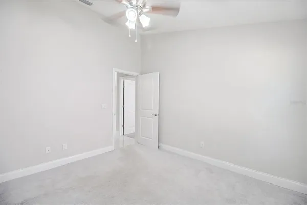 an empty room with a chandelier fan