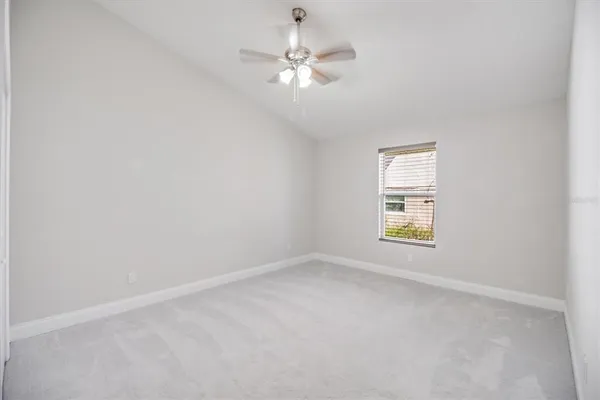 an empty room with a window and a ceiling fan