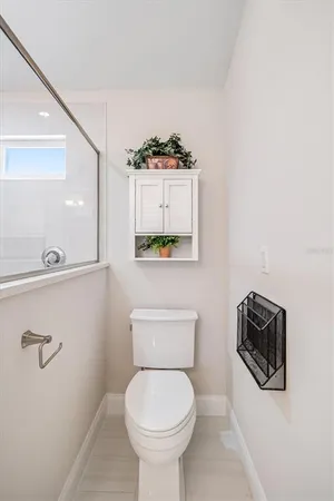 a bathroom with a toilet a sink and mirror