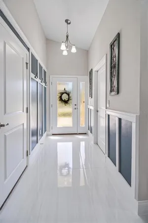 a view of a hallway with wooden floor and chandelier