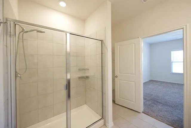 a bathroom with a shower and a glass door