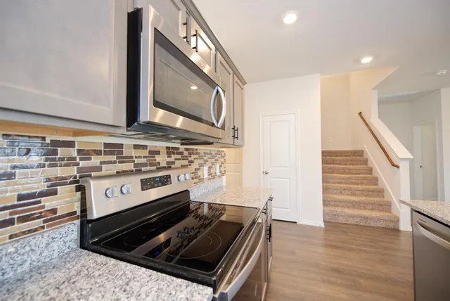 a kitchen with wooden floor and a stove top oven