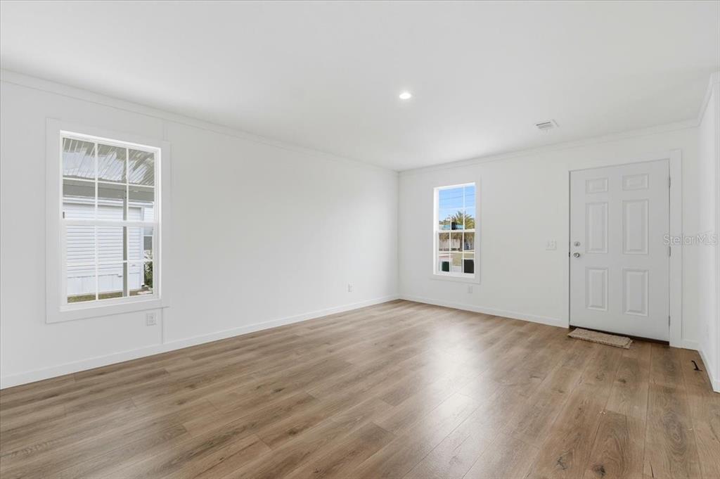 9128 Scepter Avenue Brooksville, FL 34613 - Photo 15 of 44 an empty room with wooden floor and windows