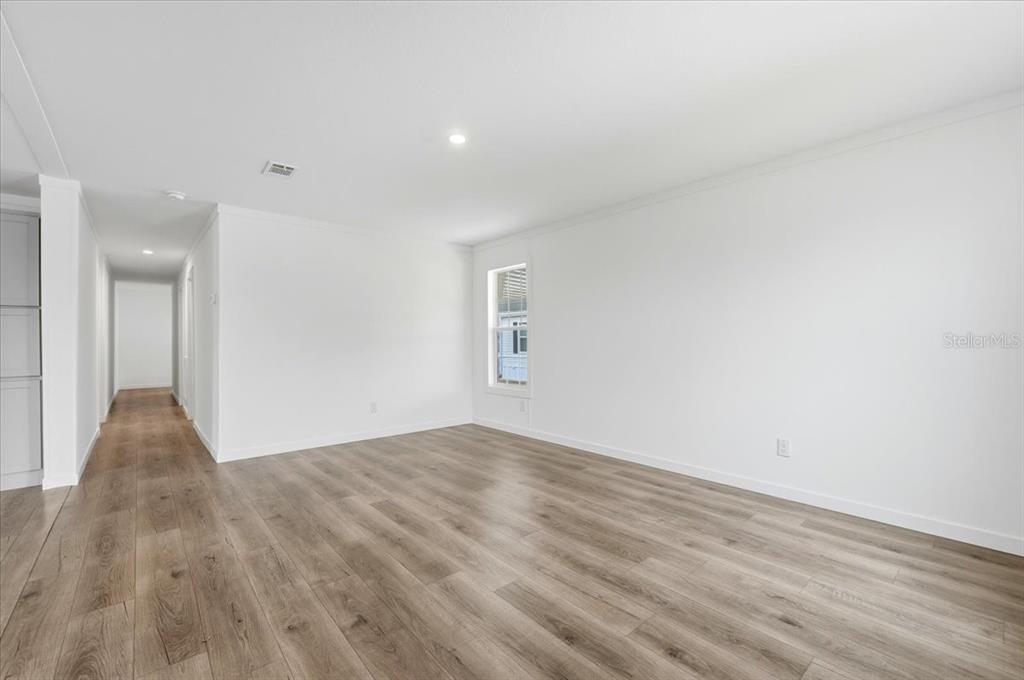 9128 Scepter Avenue Brooksville, FL 34613 - Photo 16 of 44 a view of an empty room with wooden floor and a window