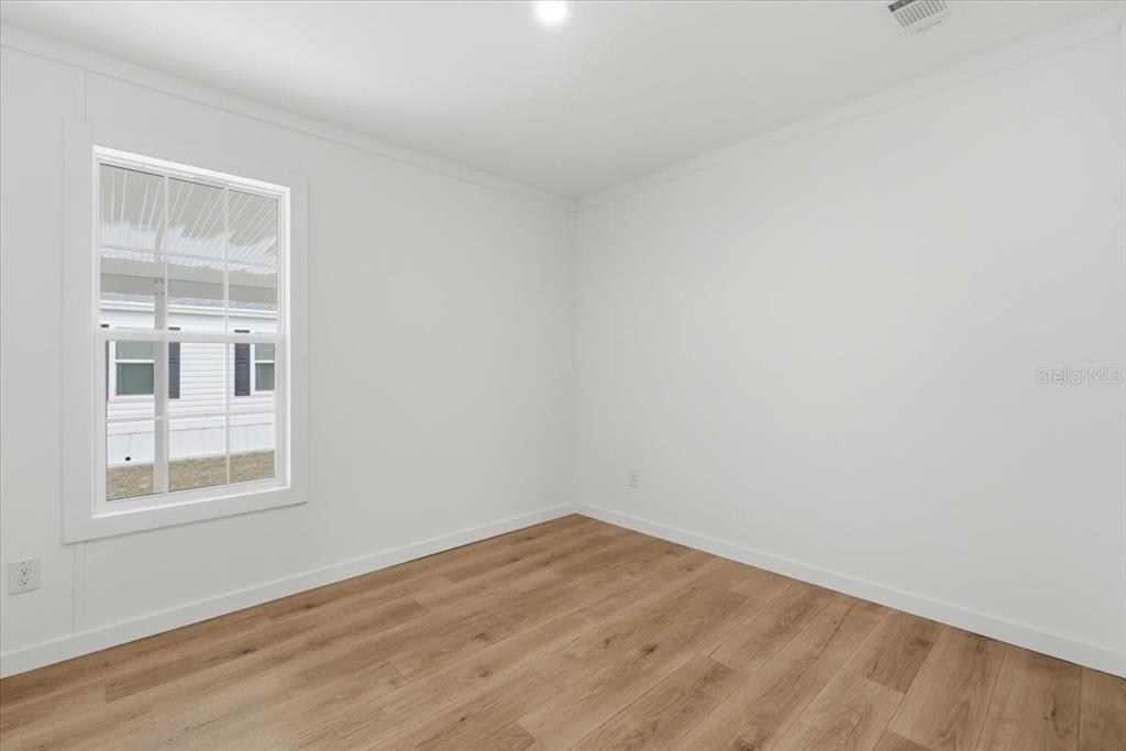 9128 Scepter Avenue Brooksville, FL 34613 - Photo 31 of 44 a view of empty room with wooden floor and fan