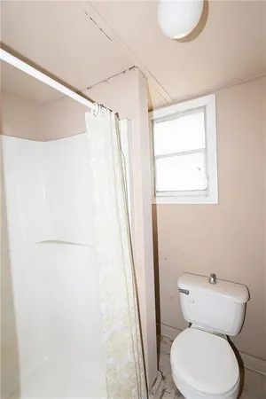 a white toilet sitting next to a shower curtain
