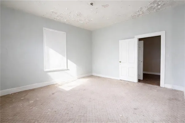 an empty room with windows and closet