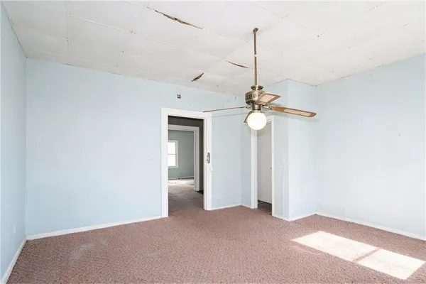 a view of a room with a ceiling fan and a window